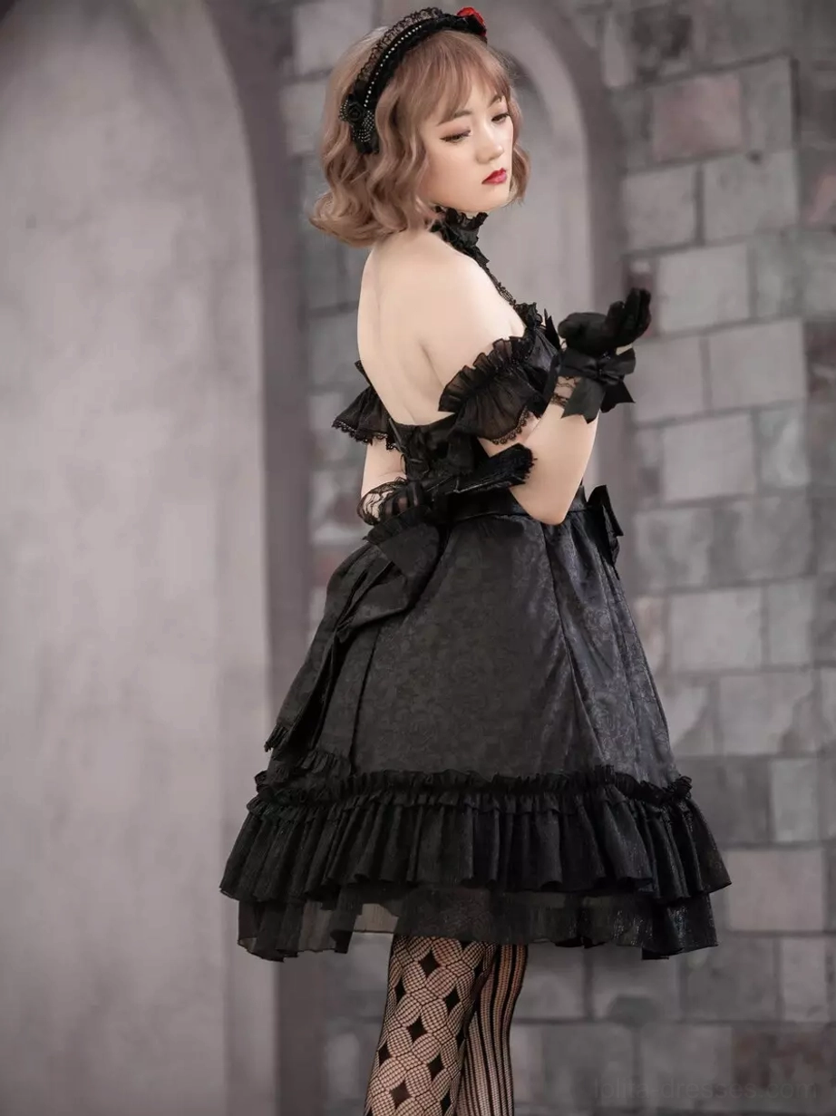Black lolita dress back view showing open back design with ruffled arm cuffs and layered ruffled skirt hem, diamond-patterned stockings