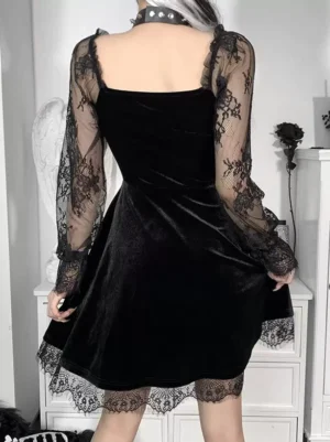 Black gothic lolita dress back full view showing square neckline, gathered velvet skirt, lace hem trim, and overall A-line silhouette with spiked choker accessory on gothic interior background