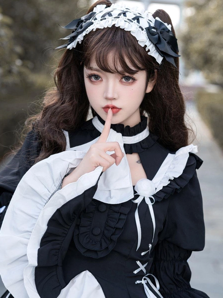 Close-up upper body detail of black gothic lolita dress highlighting ruffled bow collar, cross lace-up bodice, and puffed ruffled sleeves