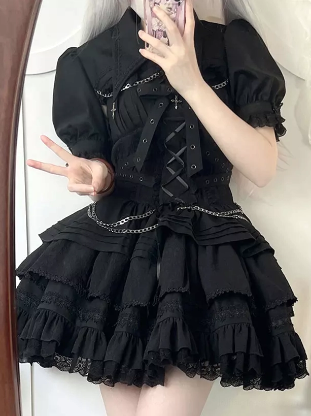 Black gothic lolita jumper dress with puff sleeves lace-up corset chain and cross decorations worn in mirror selfie front view