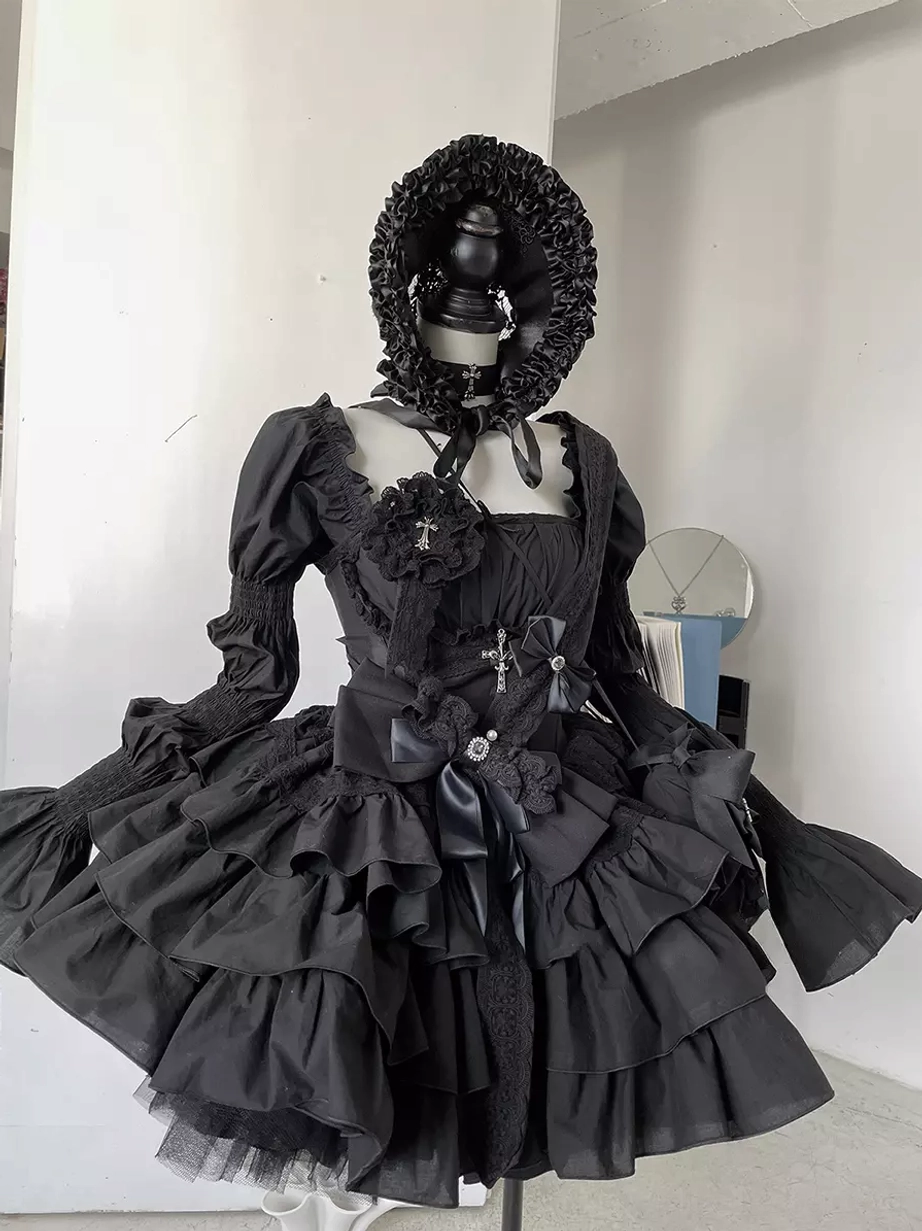 Black Gothic Lolita dress flat lay front view with detachable puff sleeves, square neckline choker, cross embellishments, tiered ruffle skirt, satin bows, and complete accessory ensemble including ruffle bucket hat, cross brooch, and mini crossbody bag