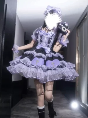 Black gothic lolita dress with layered tulle skirt heart cross motifs and pearl bow accessories three-quarter front view on model