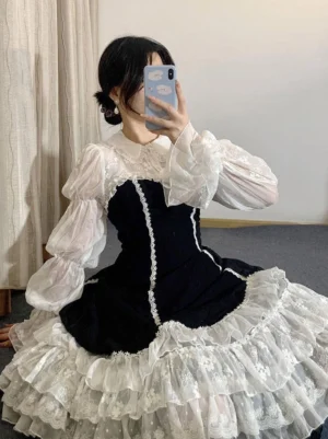 Gothic lolita dress mirror selfie indoor styling with black velvet bodice, multi-layer ruffled skirt, and sheer puff sleeves perfect for daily wear