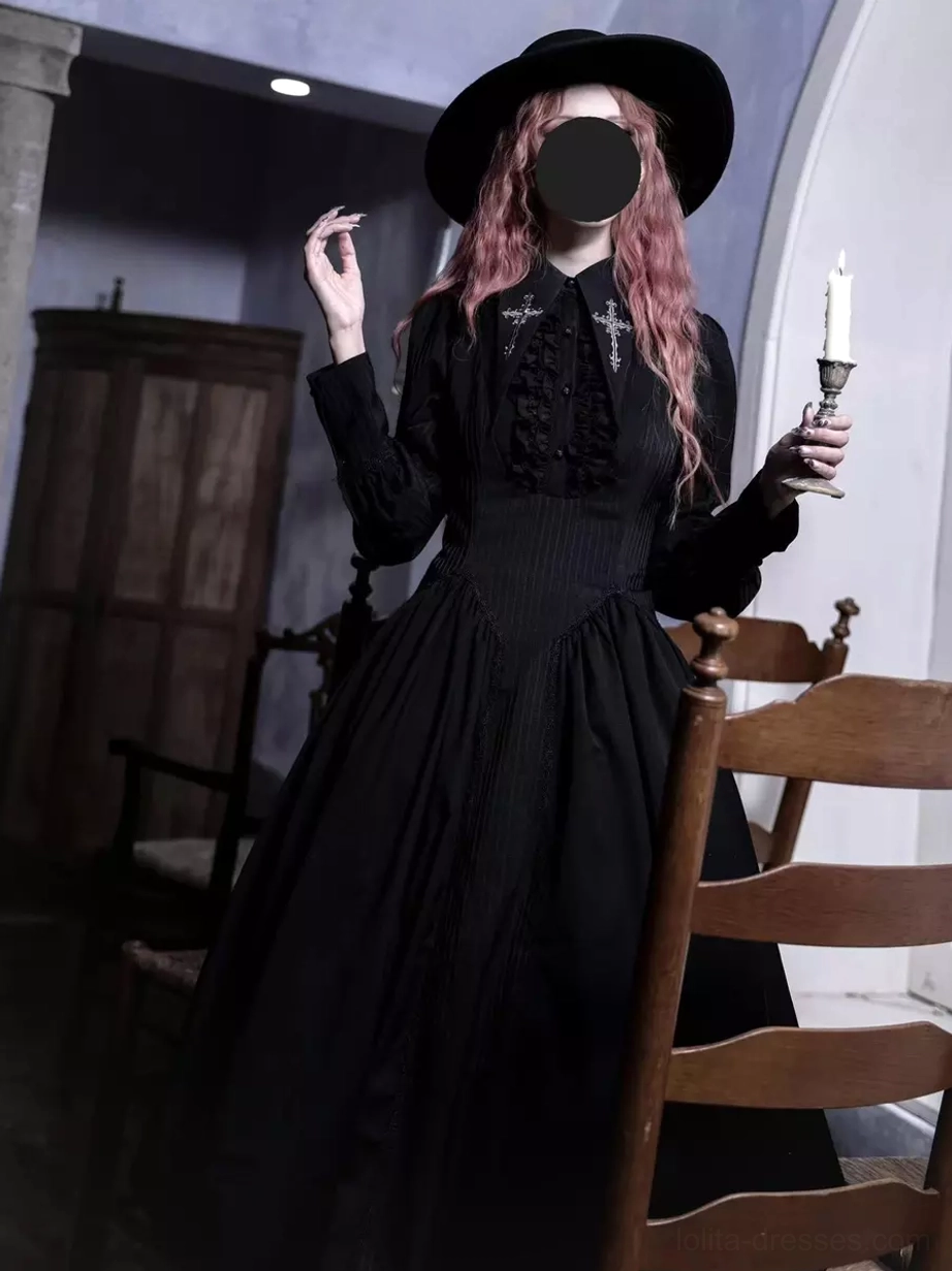 Black Gothic Lolita dress front full-body view, featuring ruffled chest decoration, long sleeves, fitted waist, full midi skirt, worn with wide-brimmed black hat and candle holder prop
