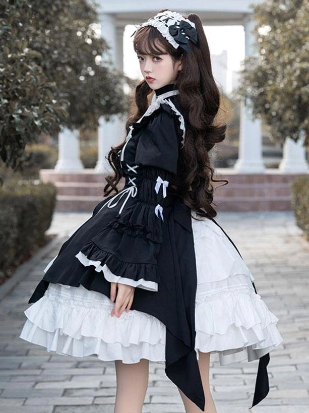 Side front full-body view of black gothic lolita dress featuring bow decorations on waist, ruffled hem, detachable long sleeves, and lace-up bodice details