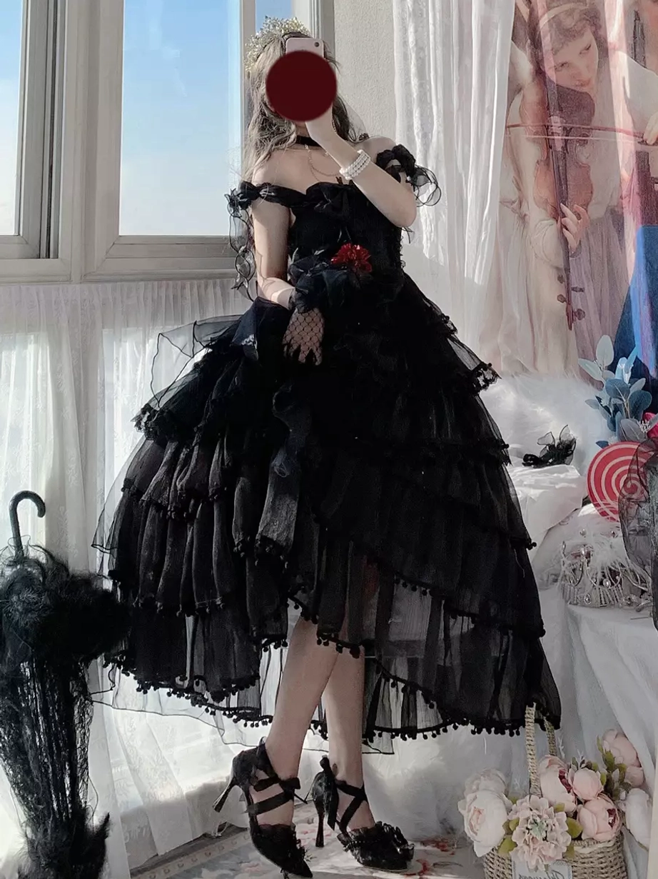 Black gothic lolita dress with off-shoulder tiered tulle skirt, red flower decoration, black heels - three-quarter side view