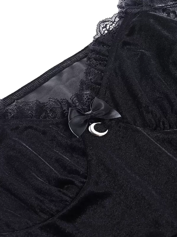 Close-up detail of black velvet fabric texture, intricate lace trim work, and decorative satin bow with moon metal charm embellishment on gothic lolita dress