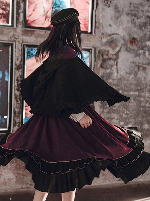 Rear back view of black lolita cape poncho showing wine red ruffled skirt trim fluttering movement gothic fashion