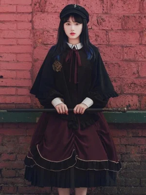 Black gothic lolita embroidered cape poncho with wine red lining worn over matching dress coordinate front full body view