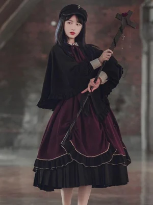Three quarter angle view of black lolita cape with ruffled cuffs embroidered details pleated skirt hem dark academic gothic style