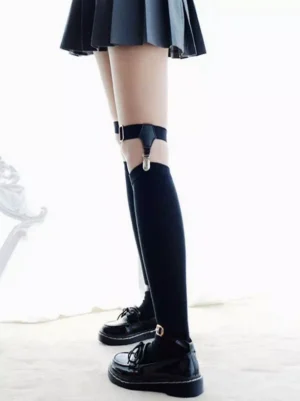 Black punk lolita leg garter and over-the-knee socks back view, featuring matte black elastic strap with silver metal fastener on female model wearing pleated skirt