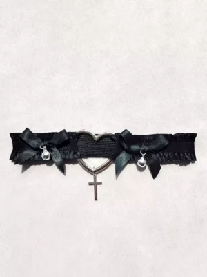black gothic lolita heart cross thigh garter with ruffled elastic band satin bow and silver bell accent flat lay view