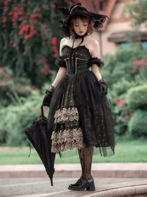 Black Gothic Lolita JSK dress with lace-up corset bodice and layered gold lace ruffles, shown on model in garden setting wearing off-shoulder design and holding black umbrella