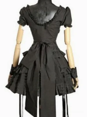 Black Gothic Lolita one-piece dress back view showing ruffled square neckline, large decorative bow sash, and layered ruffled hem, rear display on mannequin