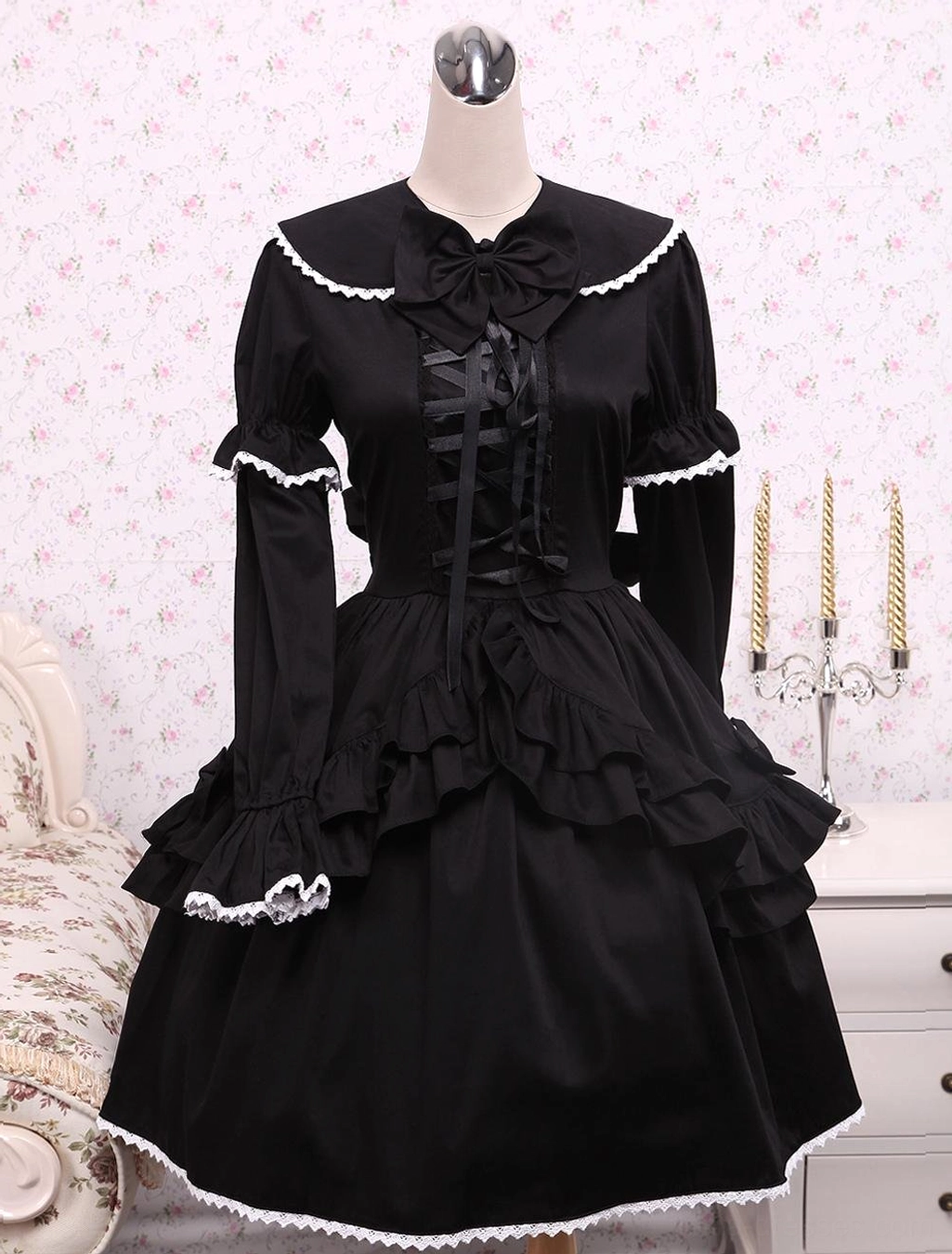 Black cotton Gothic Lolita OP dress front view on mannequin featuring white lace trim and ribbon lace-up bodice with layered ruffled skirt