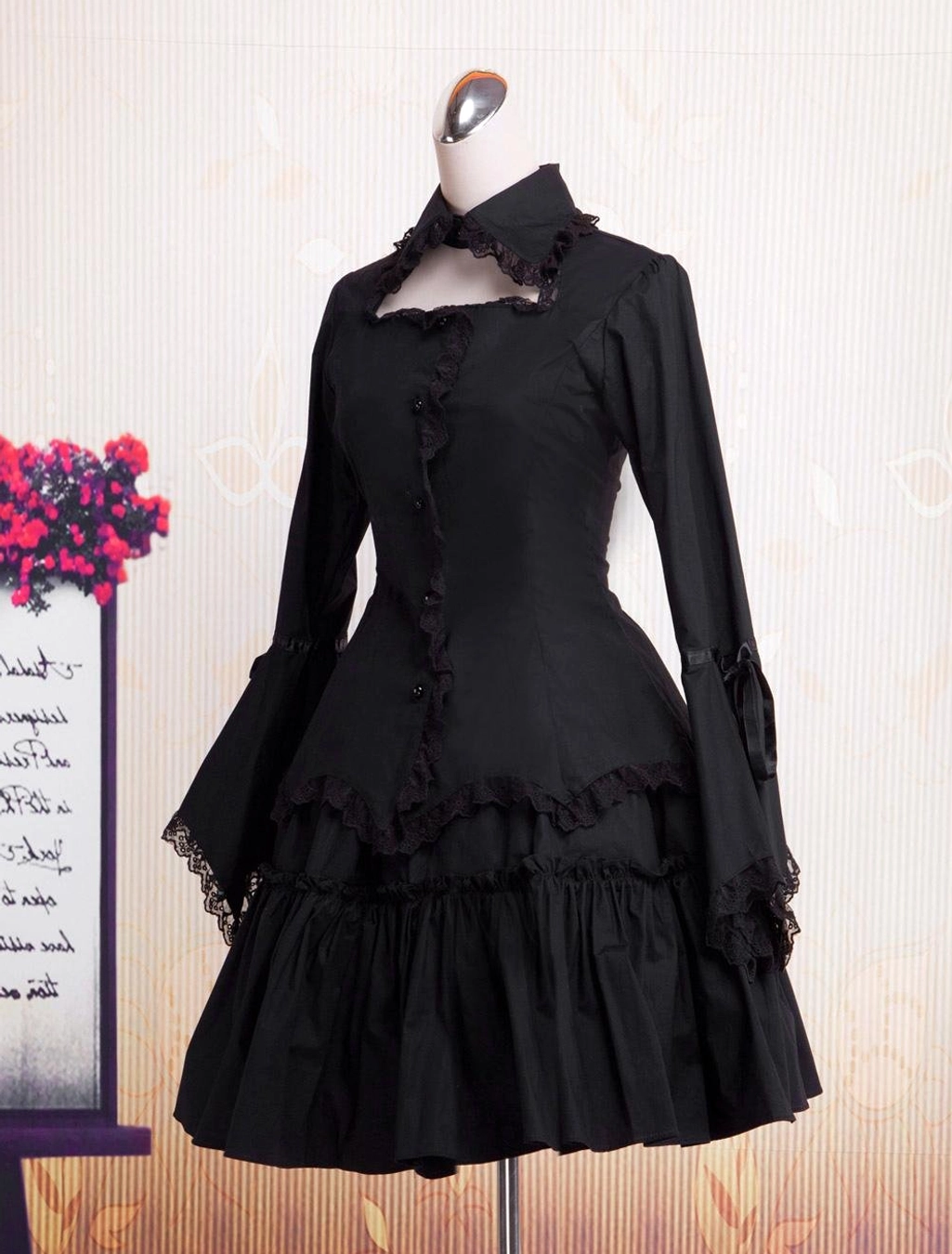 Black Gothic Lolita one-piece dress three-quarter front view with fitted waist, ribbon bow cuffs, and flared lace sleeves