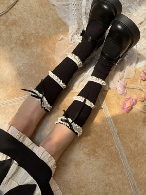 Black gothic lolita over-the-knee stockings with white ruffle lace and black bow paired with black platform mary jane shoes overhead view