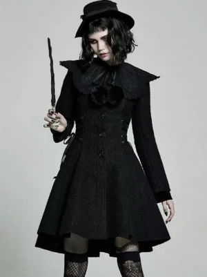 Black gothic lolita winter overcoat front view with ruffled pom-pom collar, side lacing detail, single-breasted buttons, flared midi skirt, worn with black fedora and fishnet socks