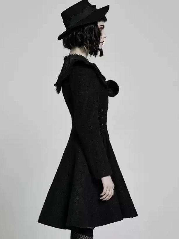 Right side profile of black gothic lolita winter overcoat with single pom-pom shoulder accent, fitted waist silhouette, flared midi skirt, complete gothic lolita styling