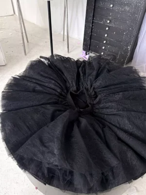 Overhead top-down view of black lolita petticoat displaying full rounded bell-curve silhouette elastic waist opening and layered tulle fabric structure
