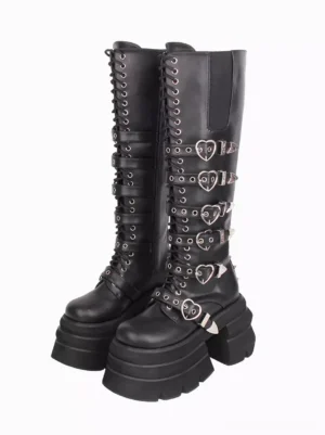 Black gothic lolita knee-high platform boots with heart-shaped metal buckles and lace-up closure paired front view against white background