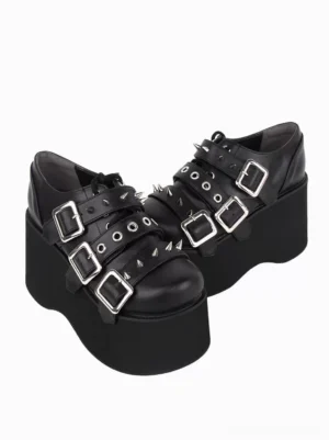 Pair of black gothic lolita platform pumps featuring round toe and metallic studs, front top-down perspective displaying decorative grommet hardware and chunky platform sole