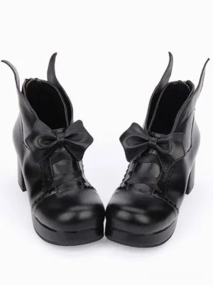 Black Gothic Lolita platform pumps with satin bow, frontal view showing ankle collar and scalloped vamp trim detail