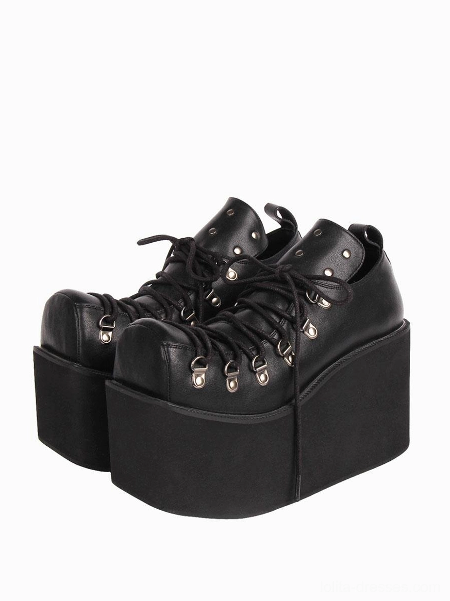 Black gothic lolita platform pumps with silver metal grommets and thick wedge heel, front paired view showing lace-up construction and round toe design
