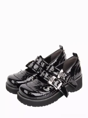 Black gothic lolita platform pumps with metal spike studs and double adjustable buckle straps, shown from oblique top-down perspective on white background, displaying scalloped shoe edge detail and glossy patent leather finish
