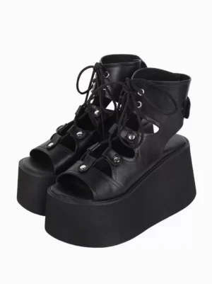 Black Gothic Lolita platform gladiator sandals with metal grommets and open toe design, three-quarter front view showing both shoes on white background