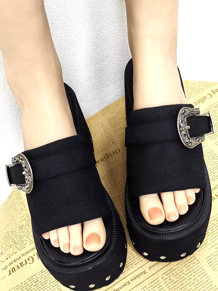 Woman wearing black gothic lolita platform sandals open toe design silver rivets wedge sole on feet