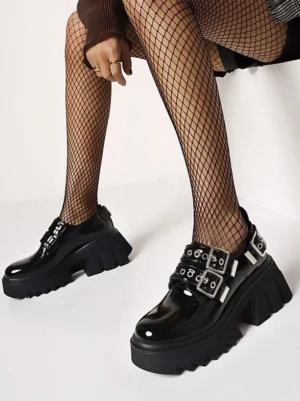 Black Gothic Lolita platform shoes with dual silver buckle straps front side view on model wearing fishnet tights studio shot