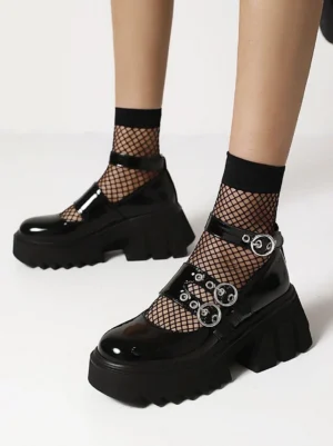 Black gothic lolita platform shoes front oblique view with double feet wearing fishnet socks, patent leather finish with triple silver buckle straps and chunky lug sole
