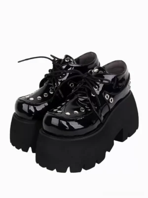 Black Gothic Lolita platform shoes with silver metallic rivets, front three-quarter pair view showing lace-up closure and patent leather finish