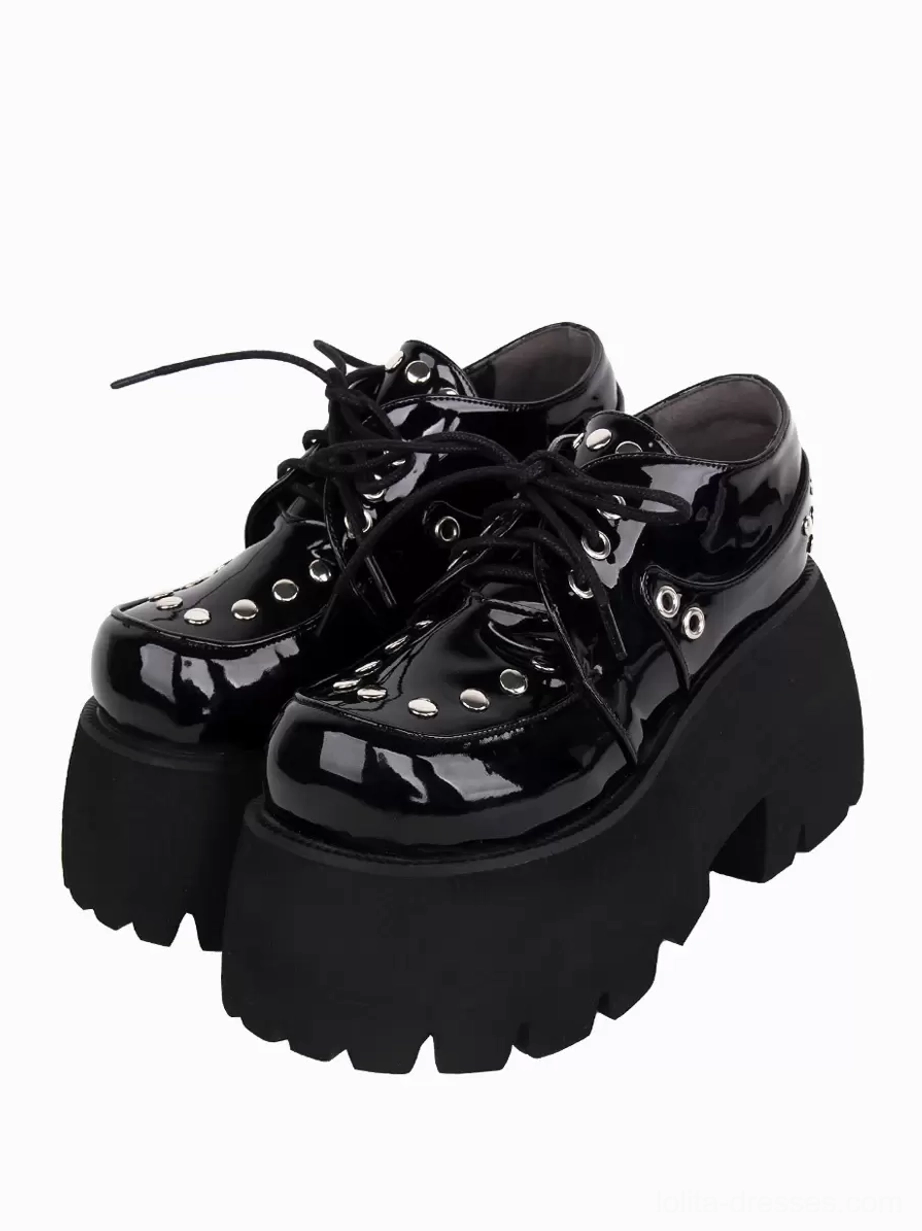 Black Gothic Lolita platform shoes with silver metallic rivets, front three-quarter pair view showing lace-up closure and patent leather finish