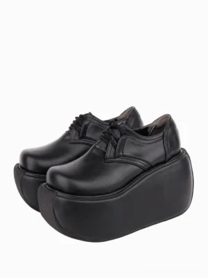 Black gothic lolita platform wedge pumps with lace-up closure and extra thick platform sole, front three-quarter view on plain white background