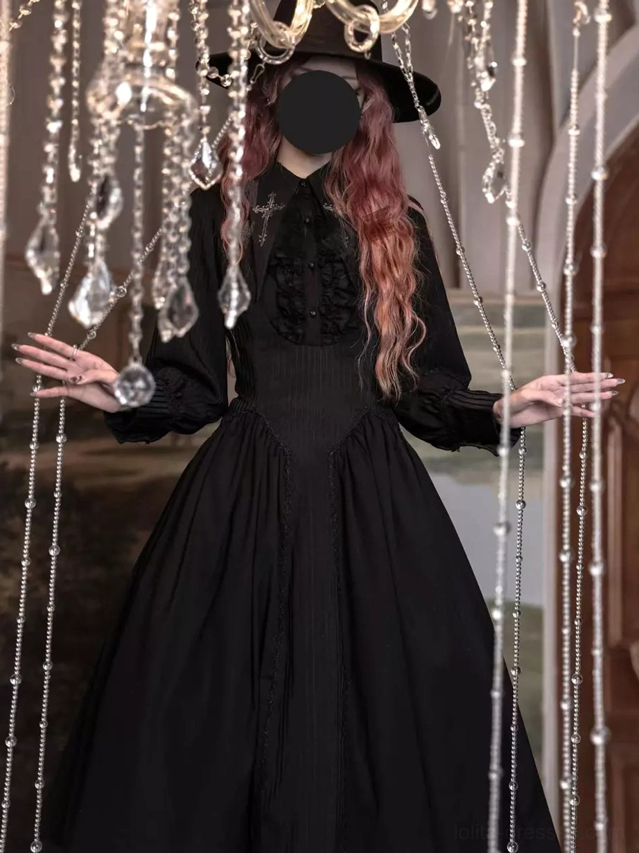 Black Gothic Lolita long sleeve midi dress front view, showing ruffled neckline, long puff sleeves, fitted waist, full flared skirt, paired with wide-brimmed black hat indoors