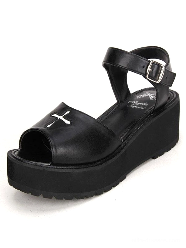 Single black gothic lolita platform sandal profile view highlighting high wedge platform, white cross embroidery on vamp, and ankle strap construction