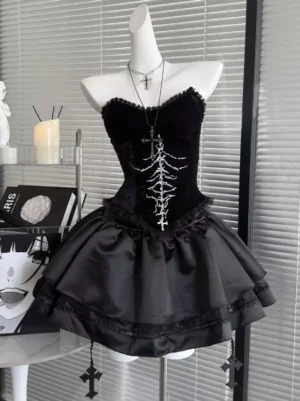 Black Gothic Lolita velvet corset JSK dress with silver skeleton print front view on mannequin showing sleeveless strapless design and satin tiered skirt with cross pendants