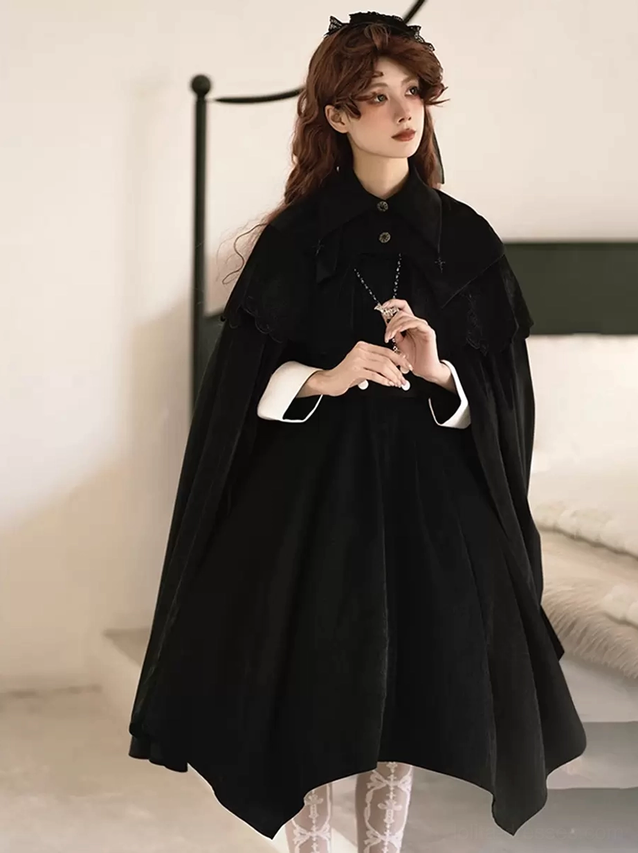 Full front view of black Gothic Lolita sleeveless cloak featuring stand collar, white contrast cuffs, pointed collar design, and smooth matte black fabric floor-length drape