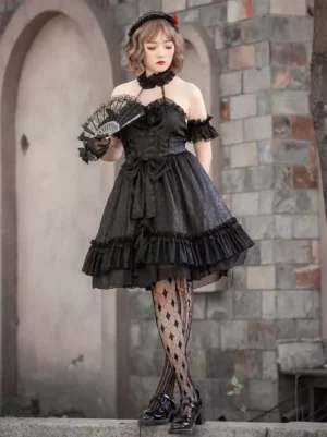 Black Gothic Lolita sleeveless dress with jacquard fabric and cascading ruffled skirt hem, featuring off-shoulder design and rose hair ornament, full front standing view
