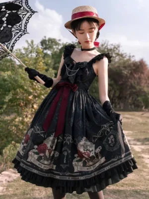Black Gothic Lolita suspender midi dress with vintage floral print and burgundy bow, worn by model outdoors in park setting with straw boater hat and black gloves, front view showcasing ruffled straps and fitted bodice