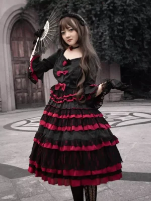 Black Gothic Lolita Tea Party dress front full-body view with jacquard lace fabric and tiered ruffles, worn by model in outdoor church courtyard setting
