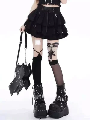 Black gothic lolita tiered mini skirt with cross rivets and D-ring details worn with thigh-high socks and platform punk boots