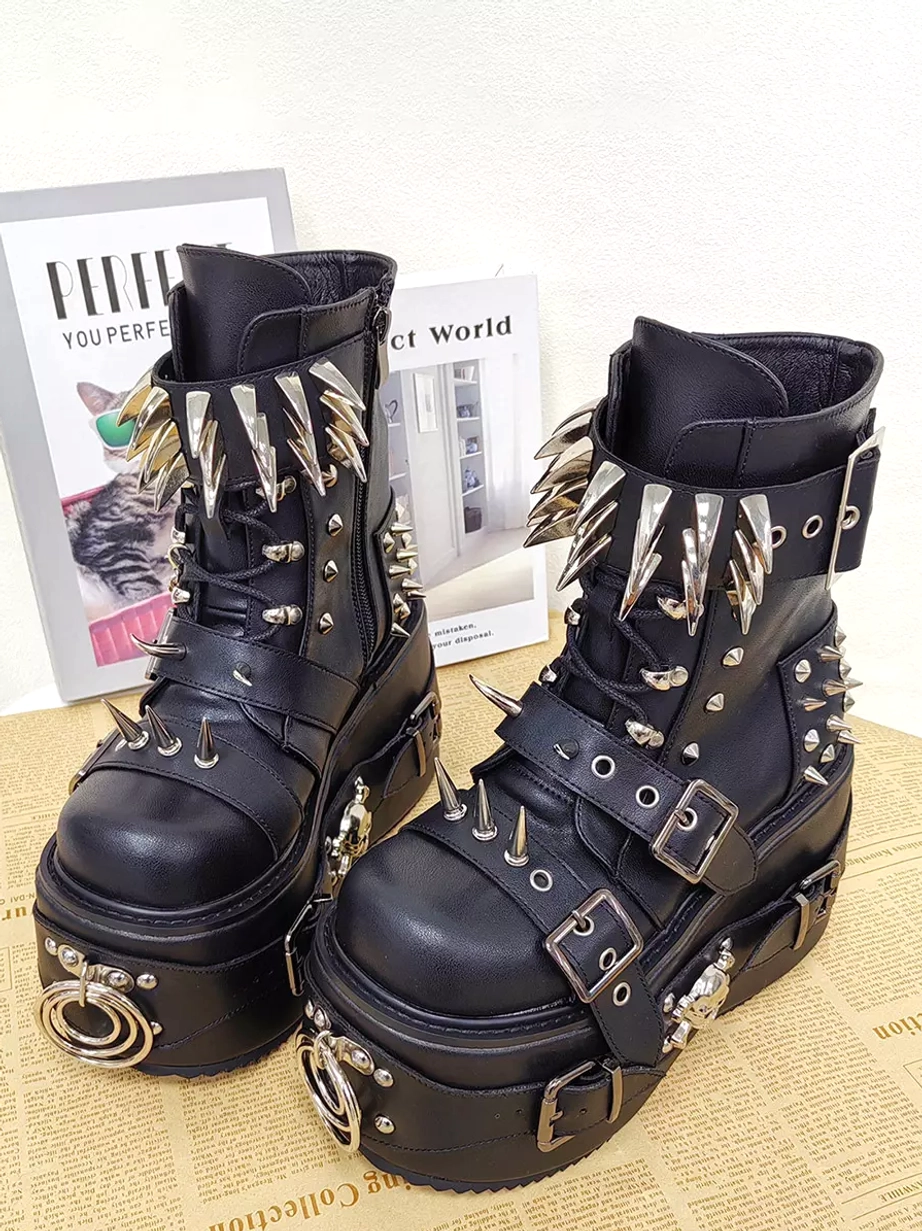 Black gothic wedge heel lolita boots front view with round toe thick sole and silver metal spike buckle hardware on vintage tabletop