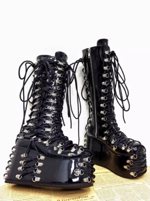 Gothic platform boots side-by-side profile view emphasizing thick platform sole, side zipper closure, and lace-up hardware metallic details against newspaper background
