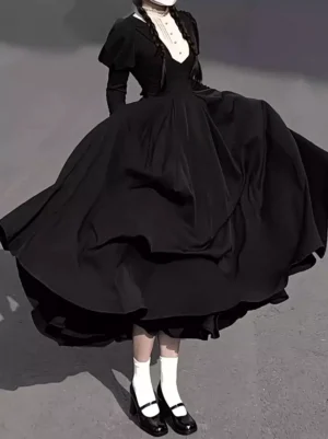 Back view of black gothic lolita nun maid costume dress showing full-length flowing skirt with bow accent detail, white socks and Mary Jane shoes