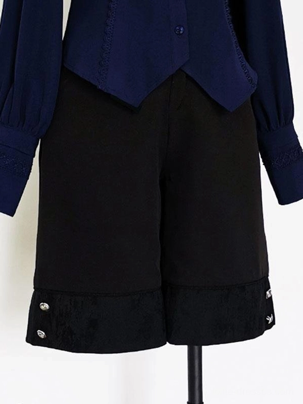 Black gothic Ouji shorts close-up flat lay jacquard woven hem fabric silver metal button accents detail