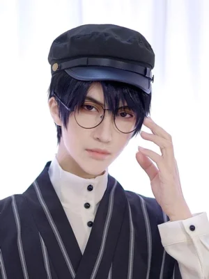Black Gothic Ouji newsboy cap front three-quarter view worn by male model in striped Ouji outfit with round glasses, featuring matte polyester fabric and leather visor with metal button detail