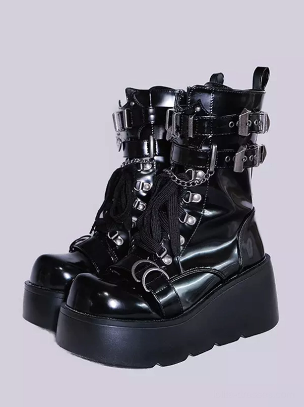Black platform combat boots static product display gray background multiple metal buckles chain accents thick platform sole front angle